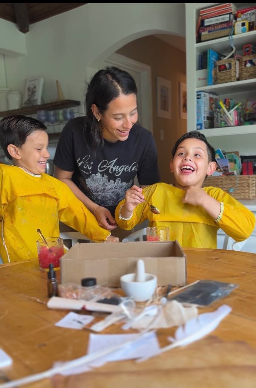 Daniela smiling with her children during a hands-on home activity